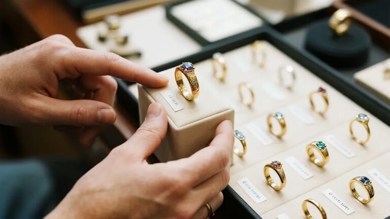 Jeweler presenting a custom gold ring to a client, highlighting personalized gold jewelry service